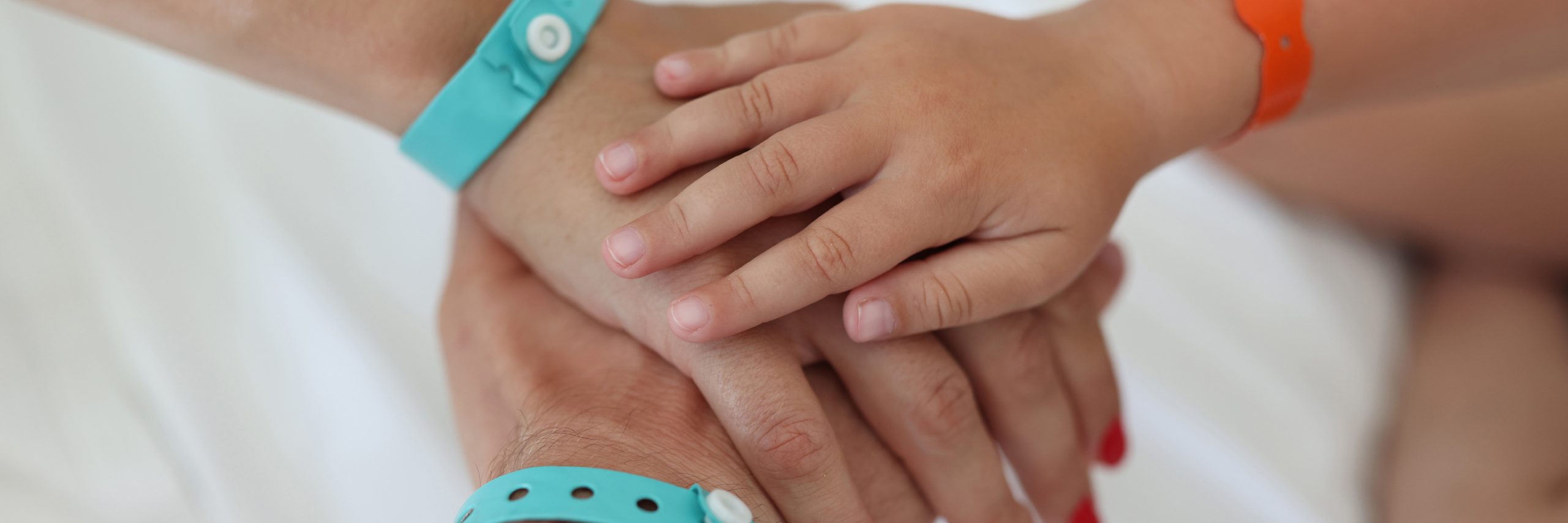 Image of adult and children's hands overlapped in unity